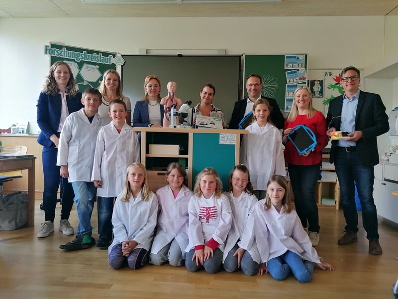 Abb.: MINT-Beauftragte: Deborah Lederer; Direktorin: Susanne Clementschitsch, Elternvertreterin: Regina Gruber; Personalleiterin SIB Combibloc Gesmbh & Co KG:  Ines Friegseder, Bürgermeister: Rudi Müllner, Technik und Design Lehrerin: Gudrun Göritzer; GF von Spürnasenecke GmbH: Josef Eder (1. Reihe von links). Florian Sch., Georg A., Sophia B., Anna-Sofie G., Hanna Sch., Paula D., Johanna N. und Emma G. (2. und 3. Reihe Kinder von links)